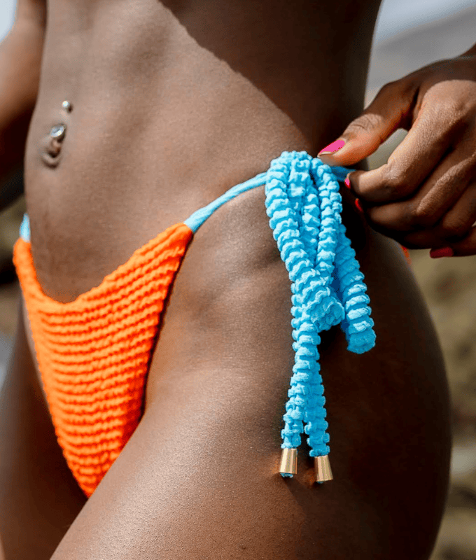 Tanga de bikini de tejido texturizado en color naranja vibrante y azul celeste