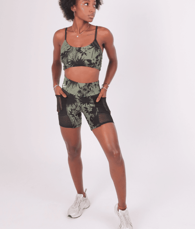 Conjunto de top deportivo y pantalón corto de bolsillos laterales en jacquard de poliamida estampado floresta tropical en colores verde militar y negro combinado con malla mesh elástica negra